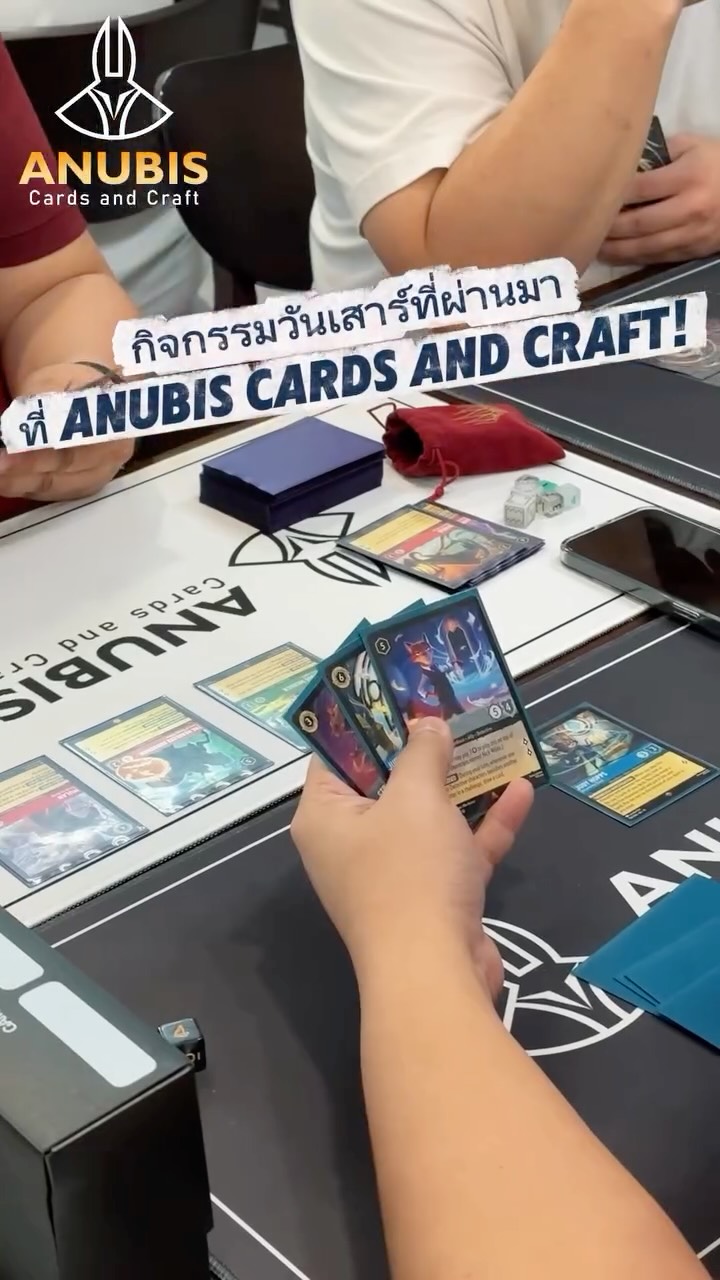 A Lorcana hand over an Anubis playmat